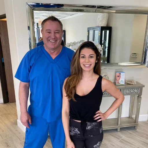 A client posing with James Hooper in the treatment studio