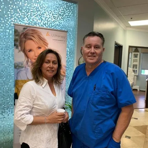 A client in a white shirt with James Hooper by the studio poster