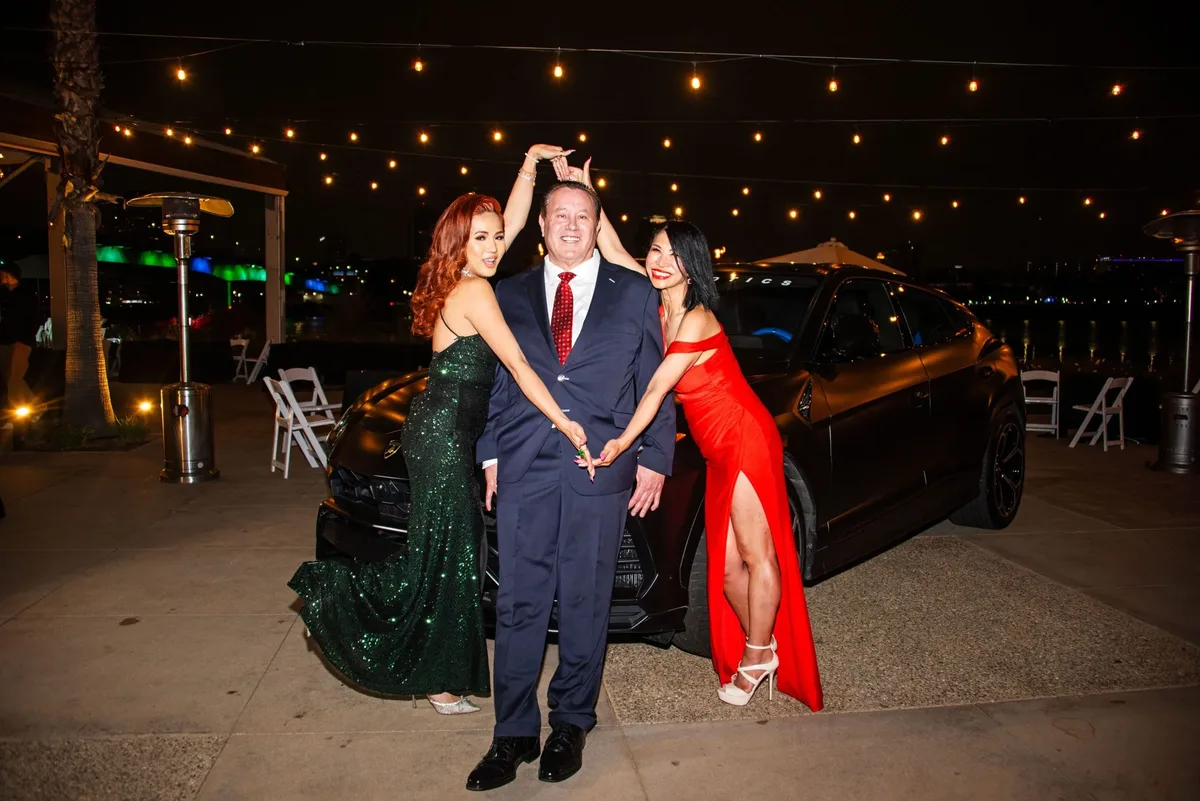 James Hooper with a guest in a red gown at an evening event