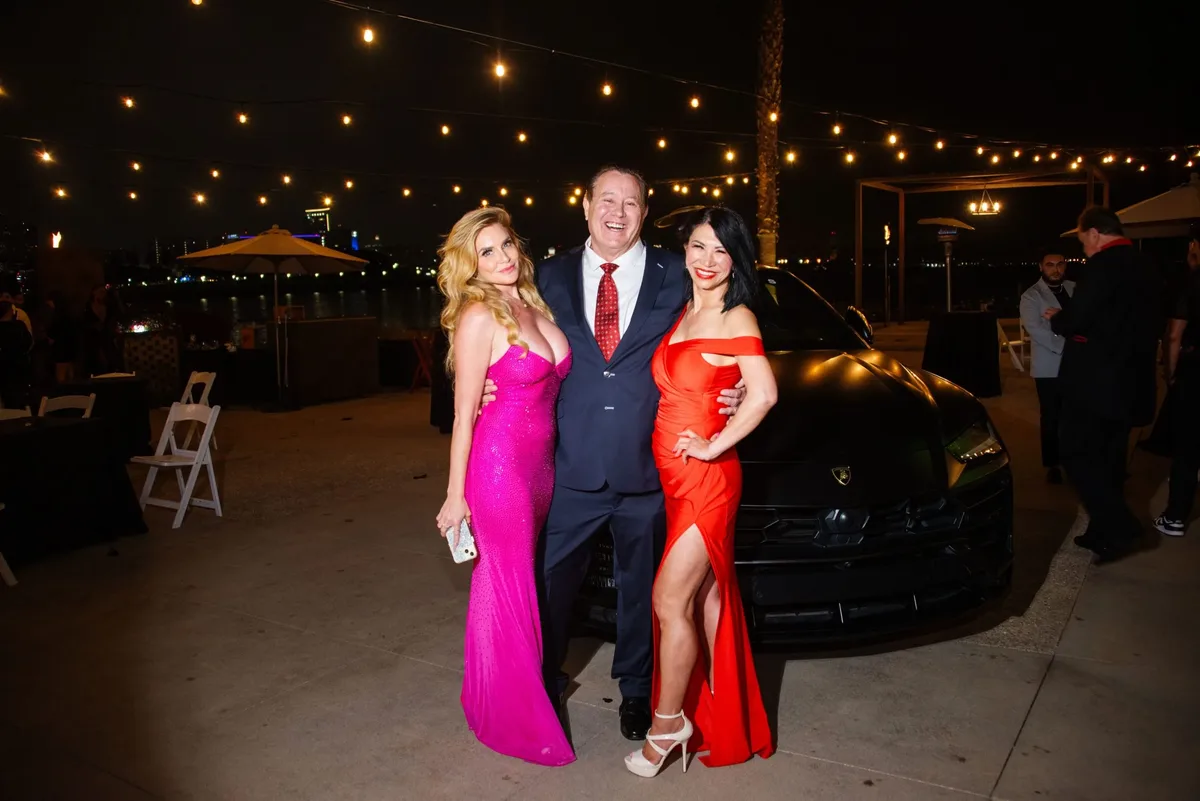 James Hooper with two guests in evening gowns at a night event