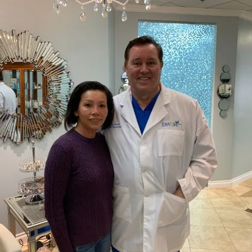 A client in a dark sweater with James Hooper in his lab coat