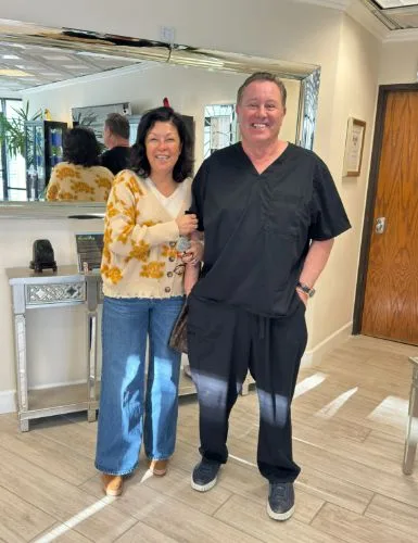 A client in a floral top with James Hooper in the hallway