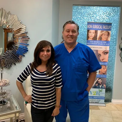 A client with James Hooper beside the treatment banner