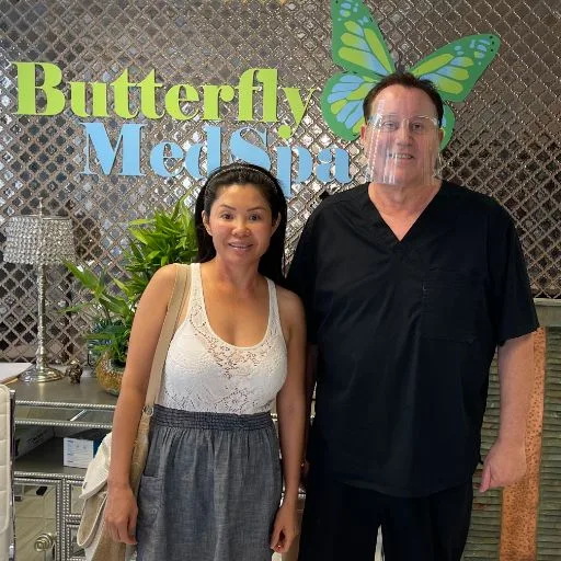 A client with James Hooper by the Butterfly MedSpa sign