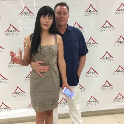 A couple at an event in front of a press backdrop