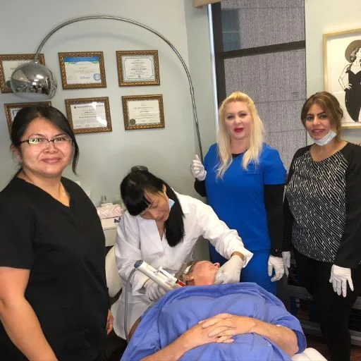 The team performing a skin-tightening treatment on a client