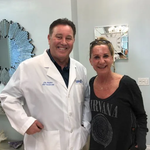 James Hooper in his lab coat with a client at the studio