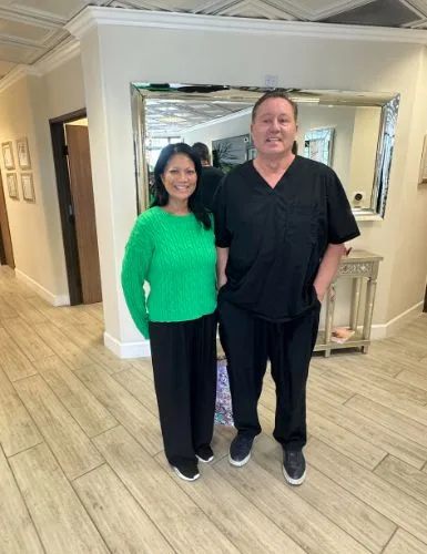 A client in a green sweater with James Hooper in the hallway