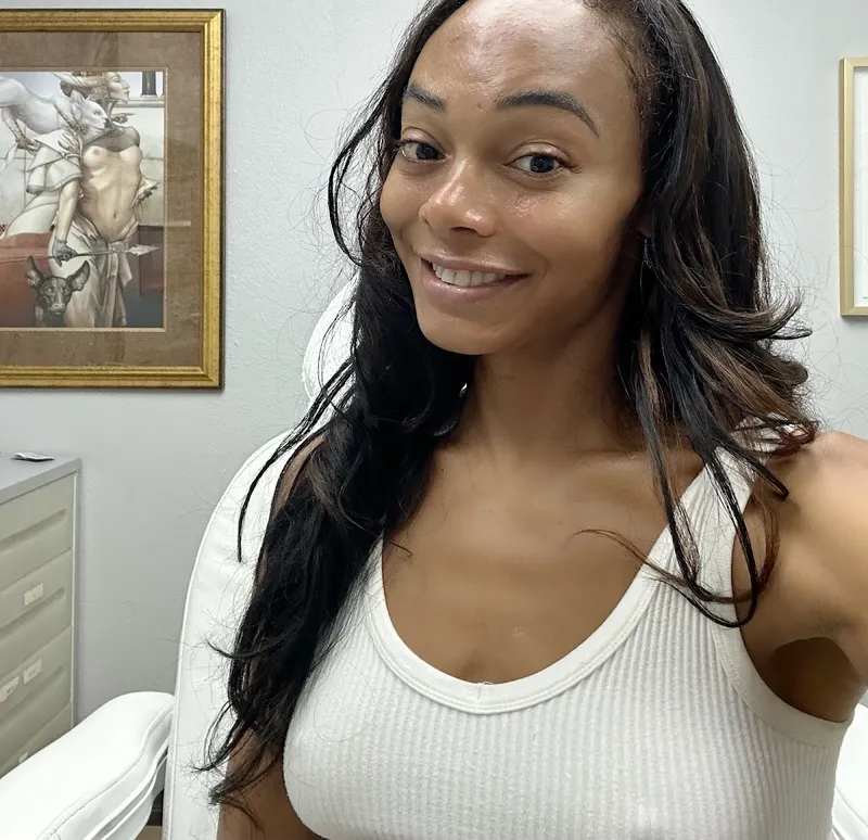 jasmine davis smiling in the treatment room at Newport Beach Skin Tightening, photo she attached to her Google review
