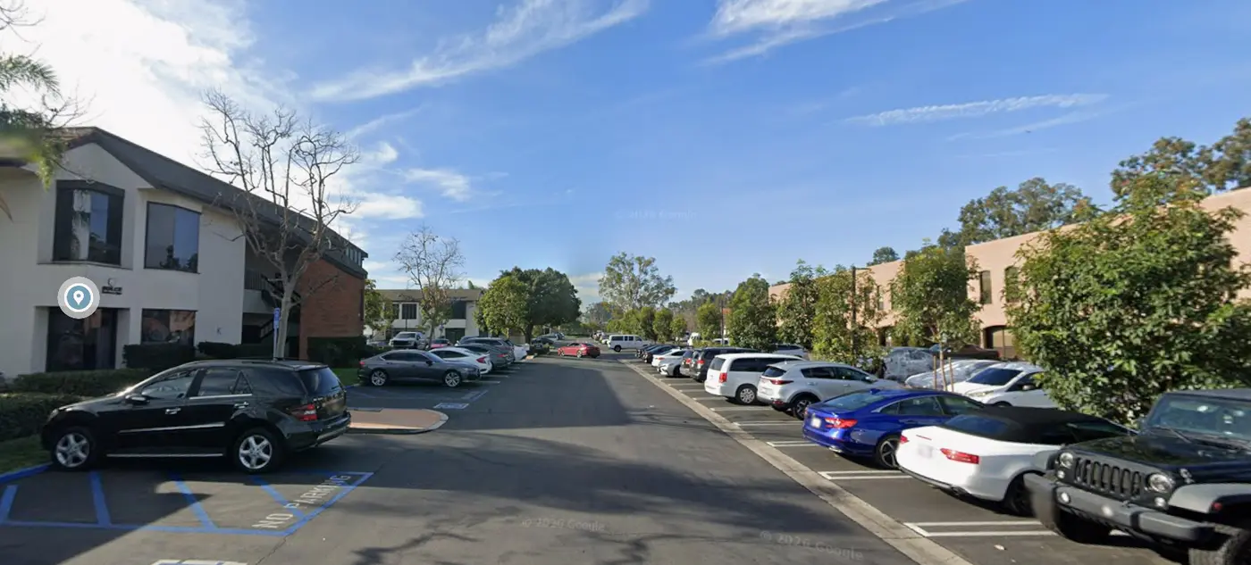 The free parking lot inside the Costa Mesa business center, with spaces along both sides of the drive directly outside the Bldg K106 offices