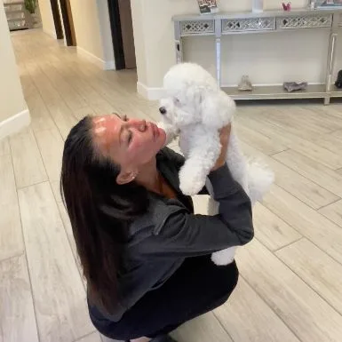 A team member lifting Lulu up for a kiss in the studio hallway