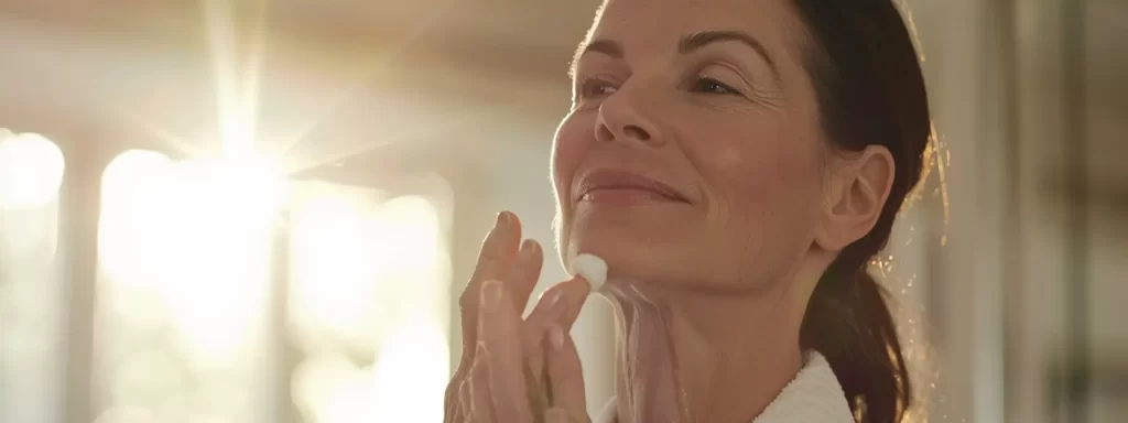 a woman gently applying soothing moisturizer to her rejuvenated skin after a laser treatment.