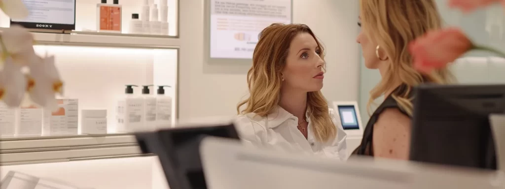 a woman sitting at a sleek, modern consultation desk, reviewing detailed financial charts and recovery timelines for various skin tightening treatments.