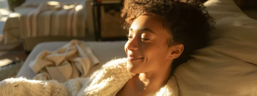 a woman with radiant skin smiling confidently as she enjoys a peaceful moment in a cozy, sunlit room.